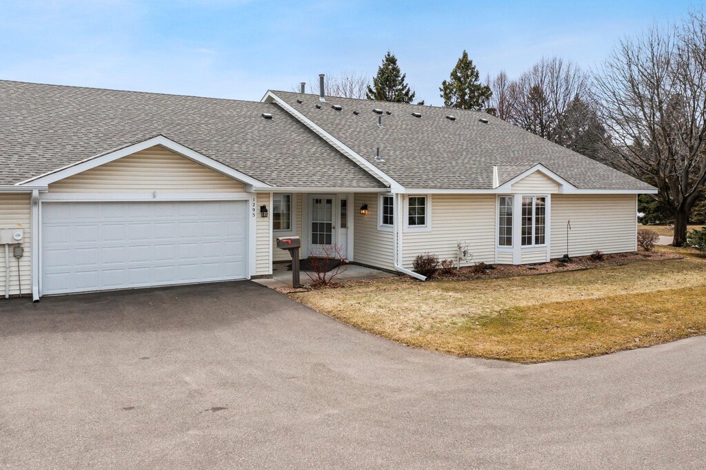 1295 Hilo Ave N, Oakdale, MN 55128 - ranch-style home featuring a front lawn, driveway, an attached garage, and roof with shingles