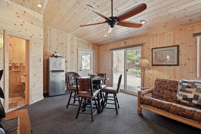 12037 Northgate Ln, Crosslake, MN 56442 - dining space featuring wooden ceiling, wood walls, ceiling fan, and dark carpet