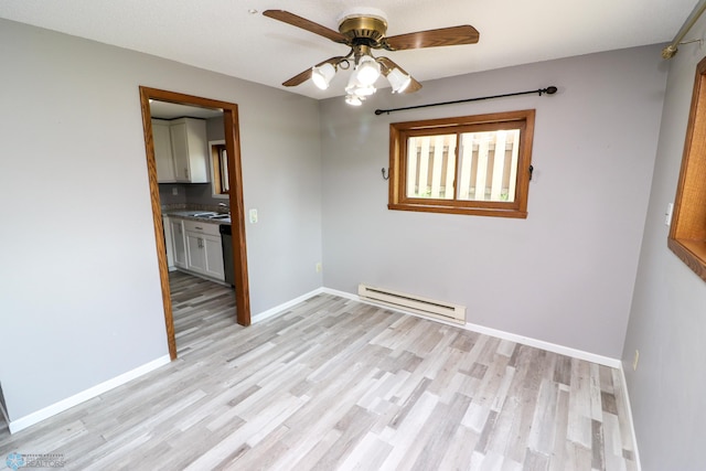 1219 7th St S Unit 1, Moorhead, MN 56560 - empty room featuring baseboard heating, light wood-style flooring, ceiling fan, and baseboards