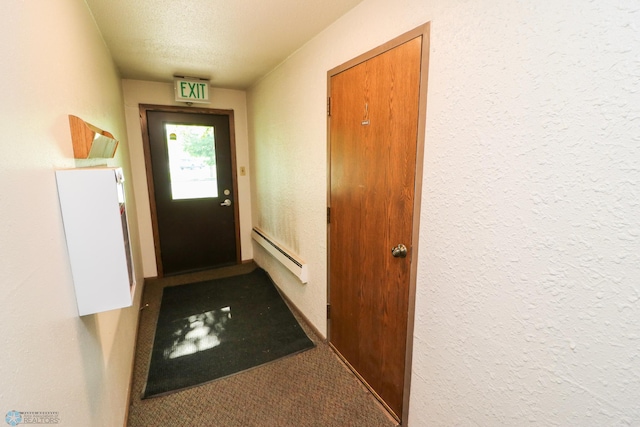 1219 7th St S Unit 1, Moorhead, MN 56560 - doorway with baseboard heating, carpet, a textured ceiling, and a textured wall