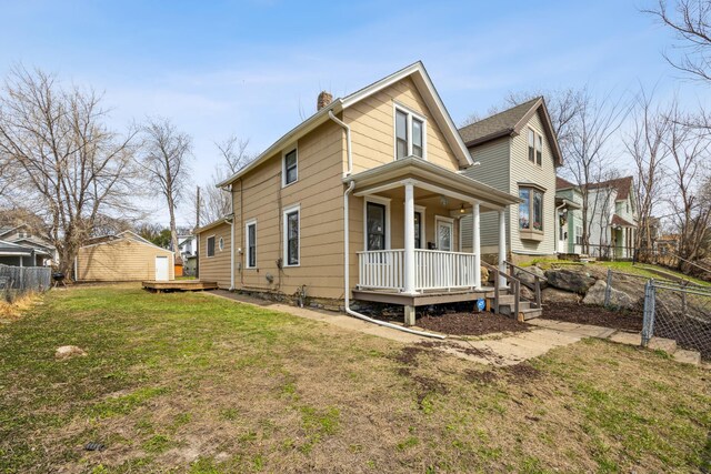 exterior space with a chimney, fence, a porch, and a yard