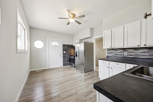 kitchen featuring a sink, dark countertops, white cabinetry, a ceiling fan, and appliances with stainless steel finishes