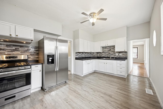 kitchen with under cabinet range hood, stainless steel appliances, a ceiling fan, a sink, and tasteful backsplash