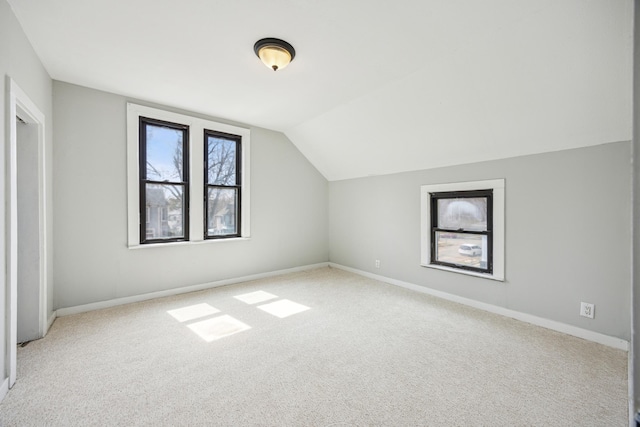bonus room featuring lofted ceiling, baseboards, and carpet