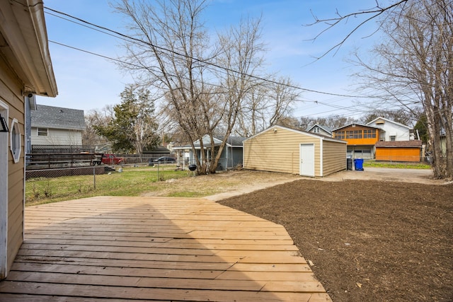 deck featuring an outdoor structure, a storage unit, and fence