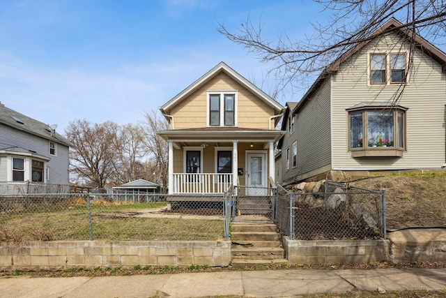 view of front facade with covered porch, a fenced front yard, and a gate