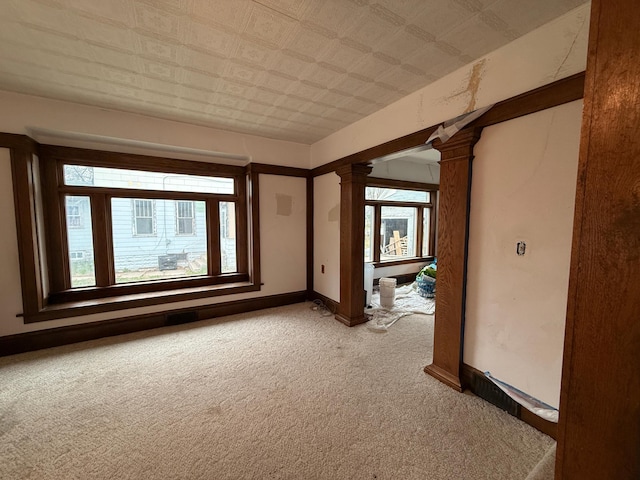 616 5th St, Madison, MN 56256 - empty room with baseboards, decorative columns, and light carpet