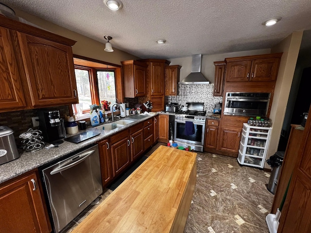 22612 Greenwood Loop, Park Rapids, MN 56470 - kitchen with wall chimney exhaust hood, stainless steel appliances, tasteful backsplash, a sink, and butcher block countertops