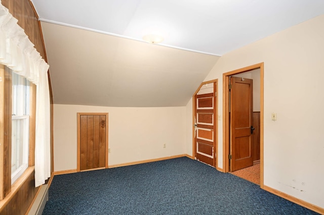 additional living space featuring vaulted ceiling, baseboards, and carpet flooring