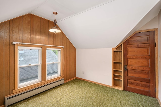 additional living space featuring a baseboard radiator, lofted ceiling, carpet, wooden walls, and baseboards