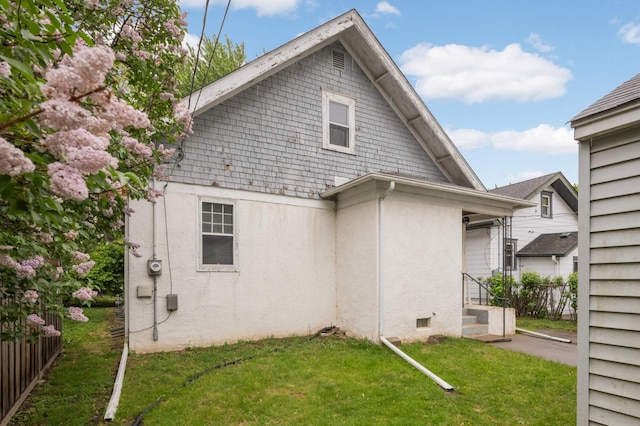 view of home's exterior featuring stucco siding and a lawn