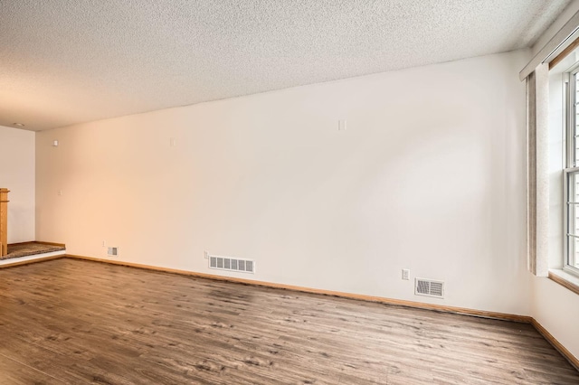 13626 Brass Pkwy Unit 27, Rosemount, MN 55068 - unfurnished room featuring visible vents, a textured ceiling, baseboards, and wood finished floors
