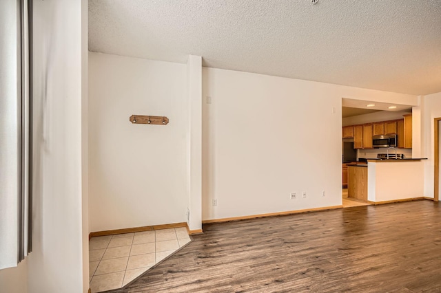 13626 Brass Pkwy Unit 27, Rosemount, MN 55068 - unfurnished living room featuring a sink, light wood-style flooring, a textured ceiling, and baseboards