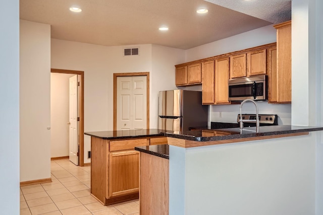 13626 Brass Pkwy Unit 27, Rosemount, MN 55068 - kitchen featuring recessed lighting, a peninsula, light tile patterned floors, visible vents, and stainless steel appliances