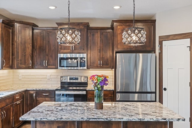 1030 Bellaire Blvd NW, Isanti, MN 55040 - kitchen with stainless steel appliances, dark brown cabinetry, light stone countertops, backsplash, and hanging light fixtures