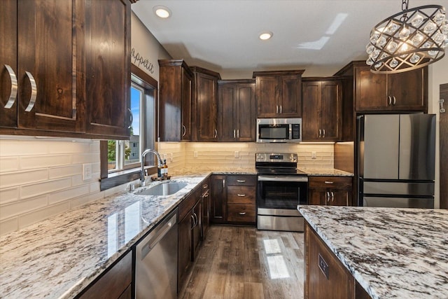 1030 Bellaire Blvd NW, Isanti, MN 55040 - kitchen featuring appliances with stainless steel finishes, a sink, dark wood-style floors, light stone counters, and dark brown cabinets