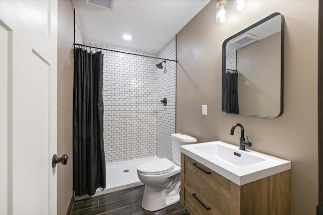 1030 Bellaire Blvd NW, Isanti, MN 55040 - bathroom featuring toilet, vanity, tiled shower, and wood finish floors