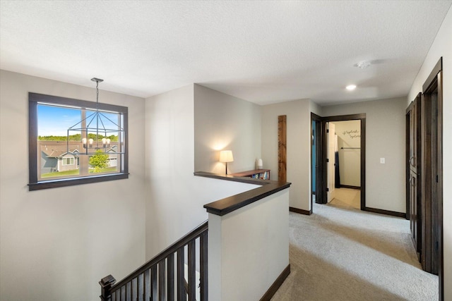 1030 Bellaire Blvd NW, Isanti, MN 55040 - hall featuring an upstairs landing, light colored carpet, a chandelier, a textured ceiling, and baseboards