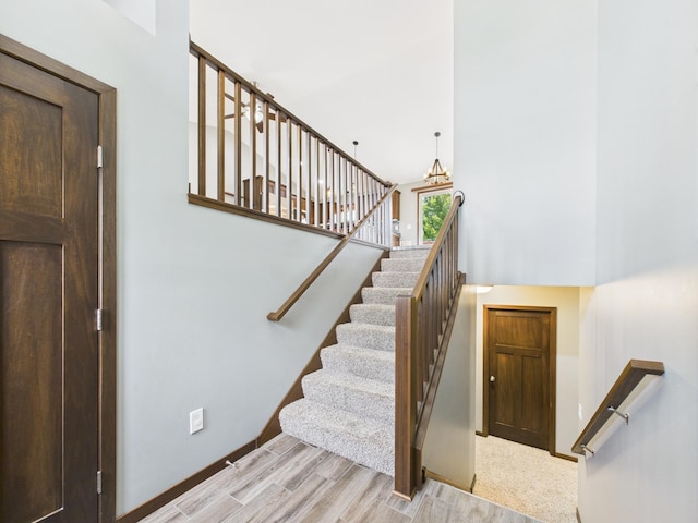 1214 Olivia St SE, New Prague, MN 56071 - stairs featuring wood finished floors, a high ceiling, and baseboards