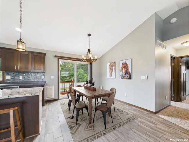 1214 Olivia St SE, New Prague, MN 56071 - dining area featuring light wood-type flooring, a chandelier, baseboards, and high vaulted ceiling