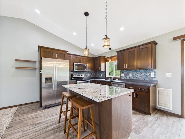 1214 Olivia St SE, New Prague, MN 56071 - kitchen featuring stainless steel appliances, vaulted ceiling, backsplash, a sink, and a center island