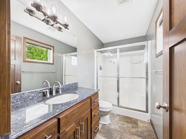 1214 Olivia St SE, New Prague, MN 56071 - bathroom with toilet, vanity, a stall shower, and stone finish floors