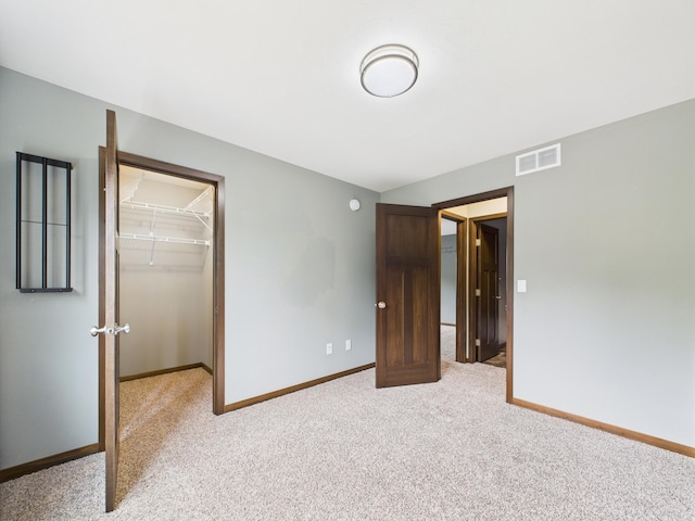 1214 Olivia St SE, New Prague, MN 56071 - unfurnished bedroom with a walk in closet, light carpet, a closet, and baseboards