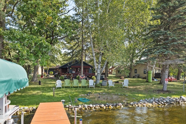 view of dock featuring a water view and a lawn