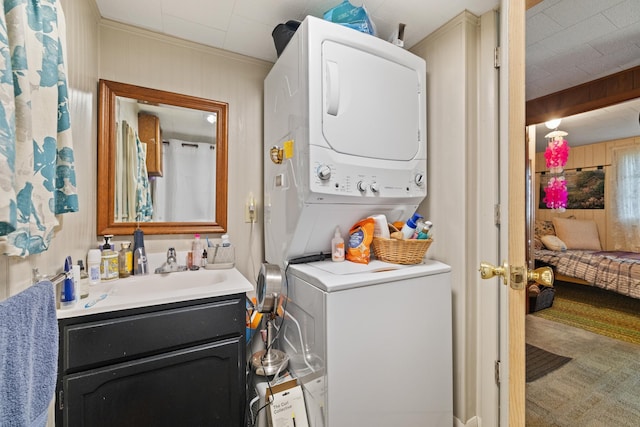 clothes washing area featuring stacked washer and dryer and a sink
