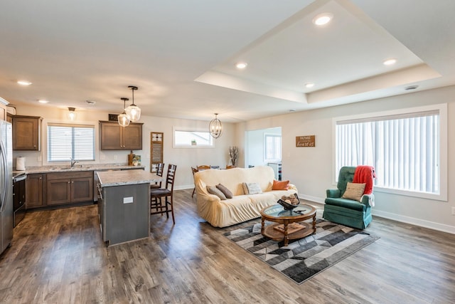 413 Fawn Run, Kenyon, MN 55946 - living room with dark wood-style flooring, baseboards, recessed lighting, and a tray ceiling