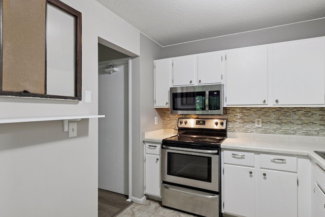 1903 Silver Bell Rd Unit 314, Eagan, MN 55122 - kitchen featuring appliances with stainless steel finishes, light countertops, white cabinets, backsplash, and a textured ceiling