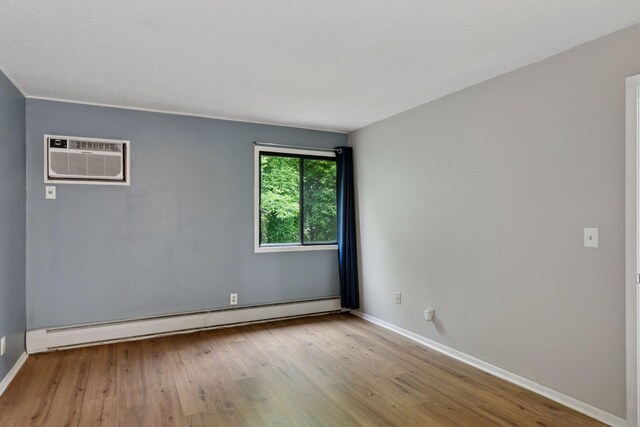 1903 Silver Bell Rd Unit 314, Eagan, MN 55122 - spare room with baseboard heating, wood finished floors, and a wall mounted AC