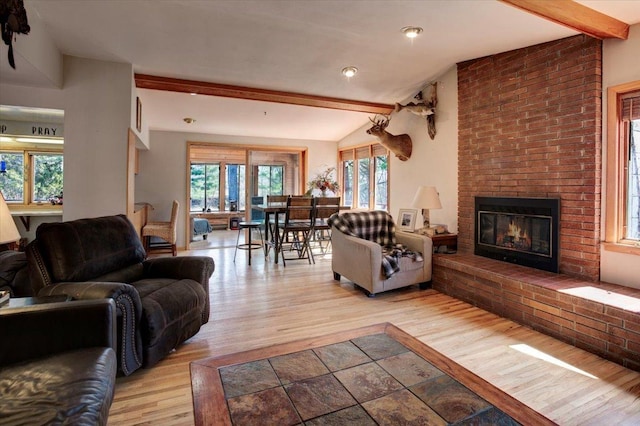 607 Cross Ave S, Amery, WI 54001 - living area with wood finished floors, a fireplace, lofted ceiling with beams, and plenty of natural light
