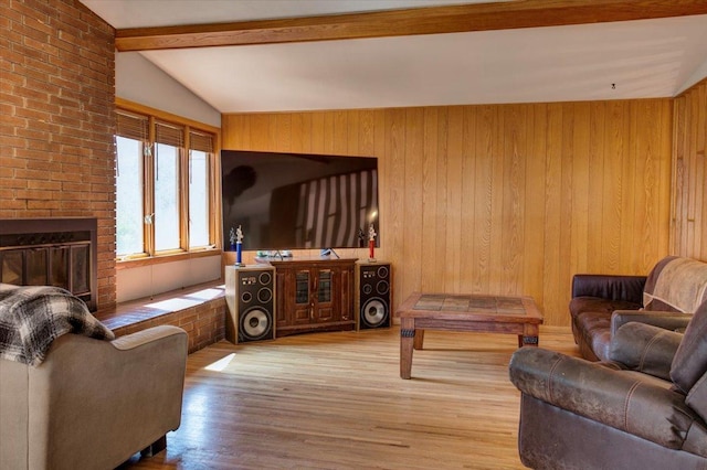 607 Cross Ave S, Amery, WI 54001 - living room with wooden walls, a brick fireplace, wood finished floors, and lofted ceiling with beams