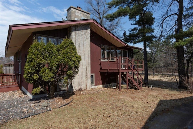 607 Cross Ave S, Amery, WI 54001 - view of side of home featuring stairs, a wooden deck, and a chimney