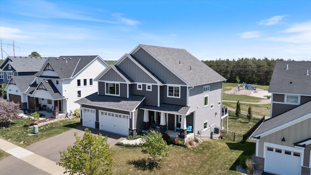 5360 Pine Island Rd, Woodbury, MN 55129 - view of front facade featuring board and batten siding, a garage, driveway, a front yard, and covered porch