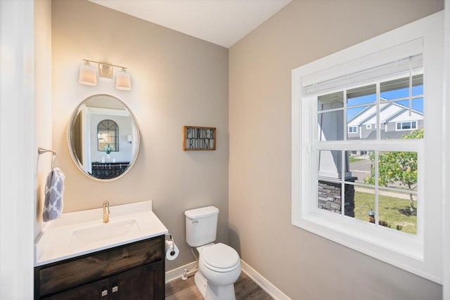 5360 Pine Island Rd, Woodbury, MN 55129 - half bathroom with toilet, baseboards, wood finished floors, and vanity
