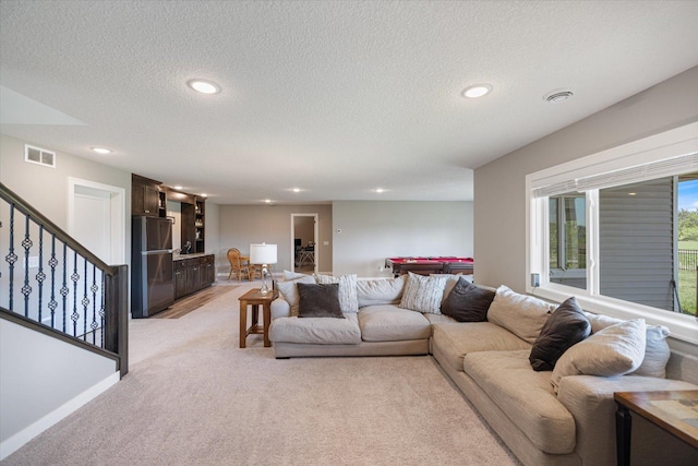 5360 Pine Island Rd, Woodbury, MN 55129 - living area featuring light colored carpet, a textured ceiling, recessed lighting, stairs, and baseboards