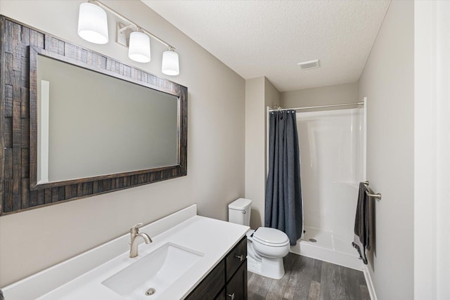 5360 Pine Island Rd, Woodbury, MN 55129 - full bath with wood finished floors, a stall shower, toilet, a textured ceiling, and vanity