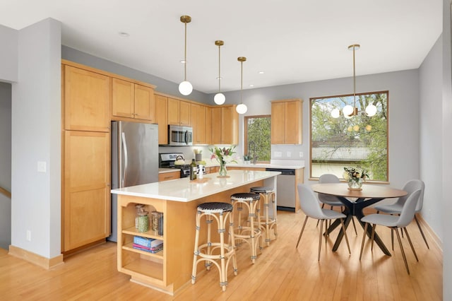 6839 Penn Ave S, Richfield, MN 55423 - kitchen with appliances with stainless steel finishes, light countertops, light wood-type flooring, a kitchen island, and open shelves