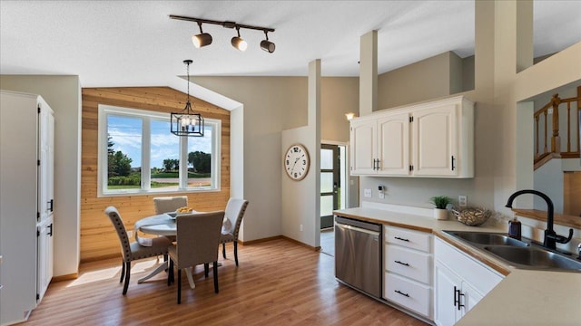 28306 State Highway 25, Belle Plaine, MN 56011 - kitchen with a sink, stainless steel dishwasher, healthy amount of natural light, white cabinetry, and wooden walls