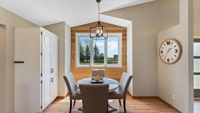 28306 State Highway 25, Belle Plaine, MN 56011 - dining space with vaulted ceiling, a chandelier, light wood-style floors, baseboards, and wooden walls
