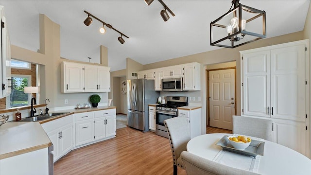 28306 State Highway 25, Belle Plaine, MN 56011 - kitchen featuring stainless steel appliances, a sink, white cabinets, vaulted ceiling, and light countertops
