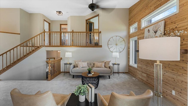 28306 State Highway 25, Belle Plaine, MN 56011 - carpeted living area with wood walls, a ceiling fan, and a towering ceiling