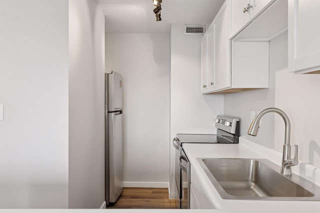 15 1st St Unit A1009, Minneapolis, MN 55401 - kitchen with dark wood finished floors, visible vents, white cabinets, a sink, and stainless steel appliances