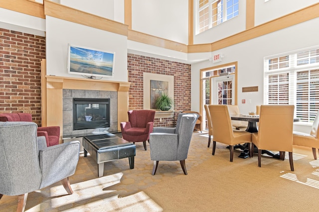 living room with a high ceiling, carpet, and a tile fireplace