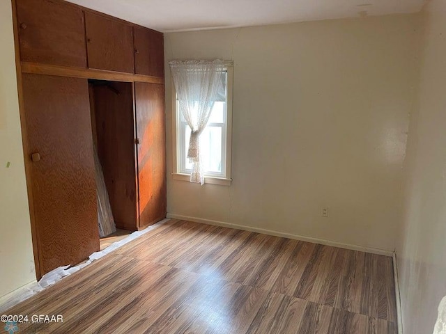 unfurnished bedroom featuring a closet, baseboards, and light wood-style floors