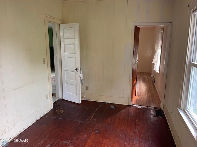 spare room featuring hardwood / wood-style floors, baseboards, and visible vents