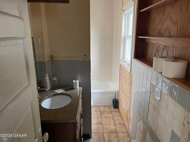 full bath with vanity and tile walls
