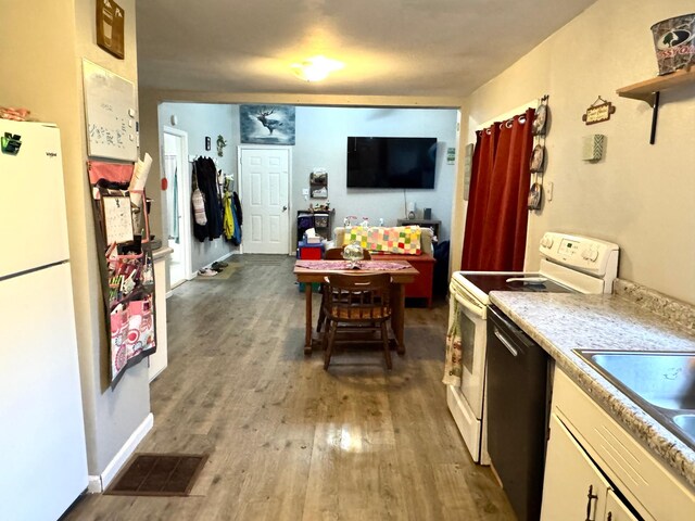 109 Rocket Dr, Badger, MN 56714 - kitchen with white appliances, wood finished floors, light countertops, a sink, and white cabinets